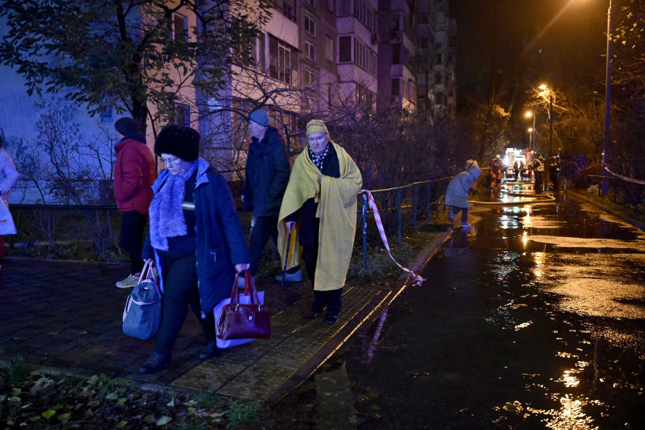 Paikalliset asukkaat poistuvat vaurioituneesta asuinrakennuksestaan ​​Venäjän Kiovaan tekemän ohjus- ja drooni-iskujen jälkeen.
