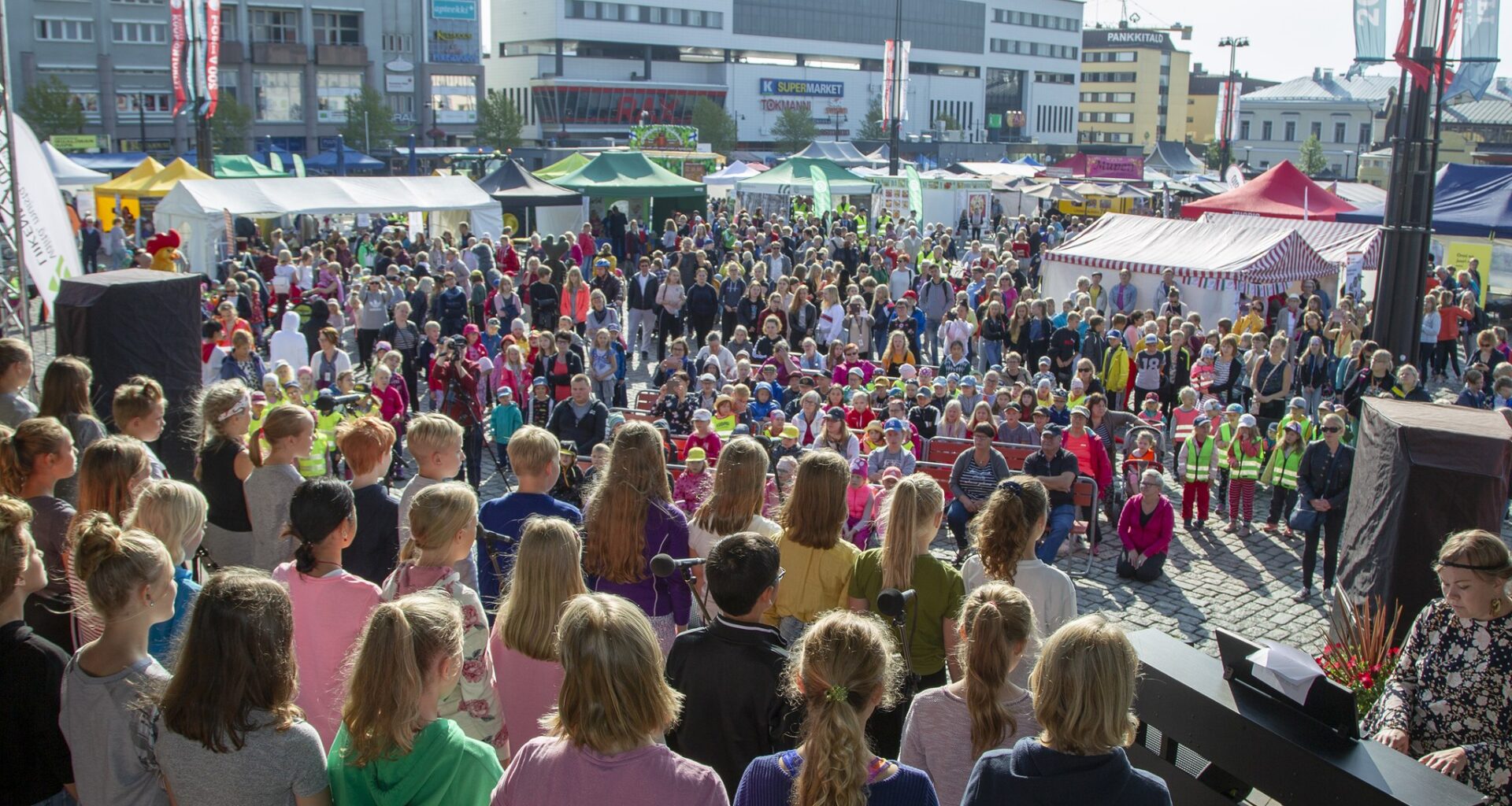 Kuva koulurauhanjulistuksesta, lavalla esiintyy lapsia ja yleisössä on myös lapsiryhmiä