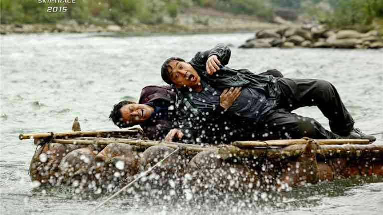 Johnny Knoxville (t.v.) och Jackie Chan ligger på någon sorts flotte genomblöta.