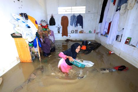 Nainen yritti pelastaa omaisuuttaan tulvaveden valtaamassa talossa Sumatran Meureudun alueella maanantaina.