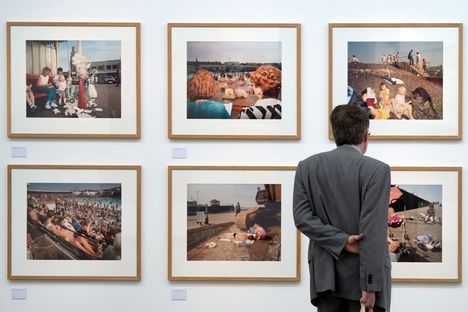 Martin Parrin valokuvanäyttelyn kävijä seisoo kuuluisan ‘'The Last Resort’'- sarjan kuvien edessä NRW-foorumissa Düsseldorfissa 18. heinäkuuta 2019. Parrin tyyli muovasi brittiläistä dokumentaarista valokuvaa mustavalkoisesta ja jäykästä representaatiosta kohti värikkäämpää ja eläväisempää kuvaa.