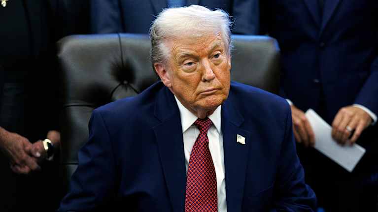 Trump istuu ja katsoo etuviistoon.