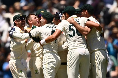 Kuvan Australian joukkue juhli kentällä, Englanti sen ulkopuolella.