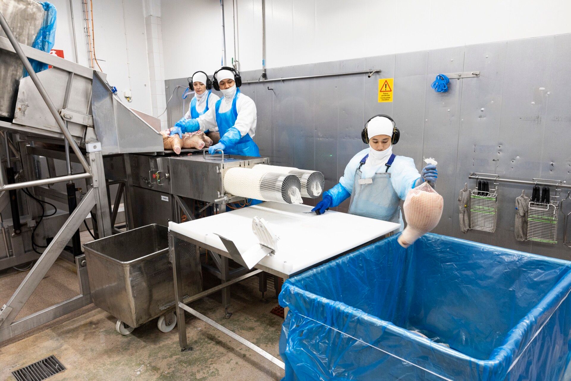 Metallilaatikot kipataan linjastolle ja työnnetään verkkoputken läpi. Siitä kinkut saavat verkon ympärilleen.