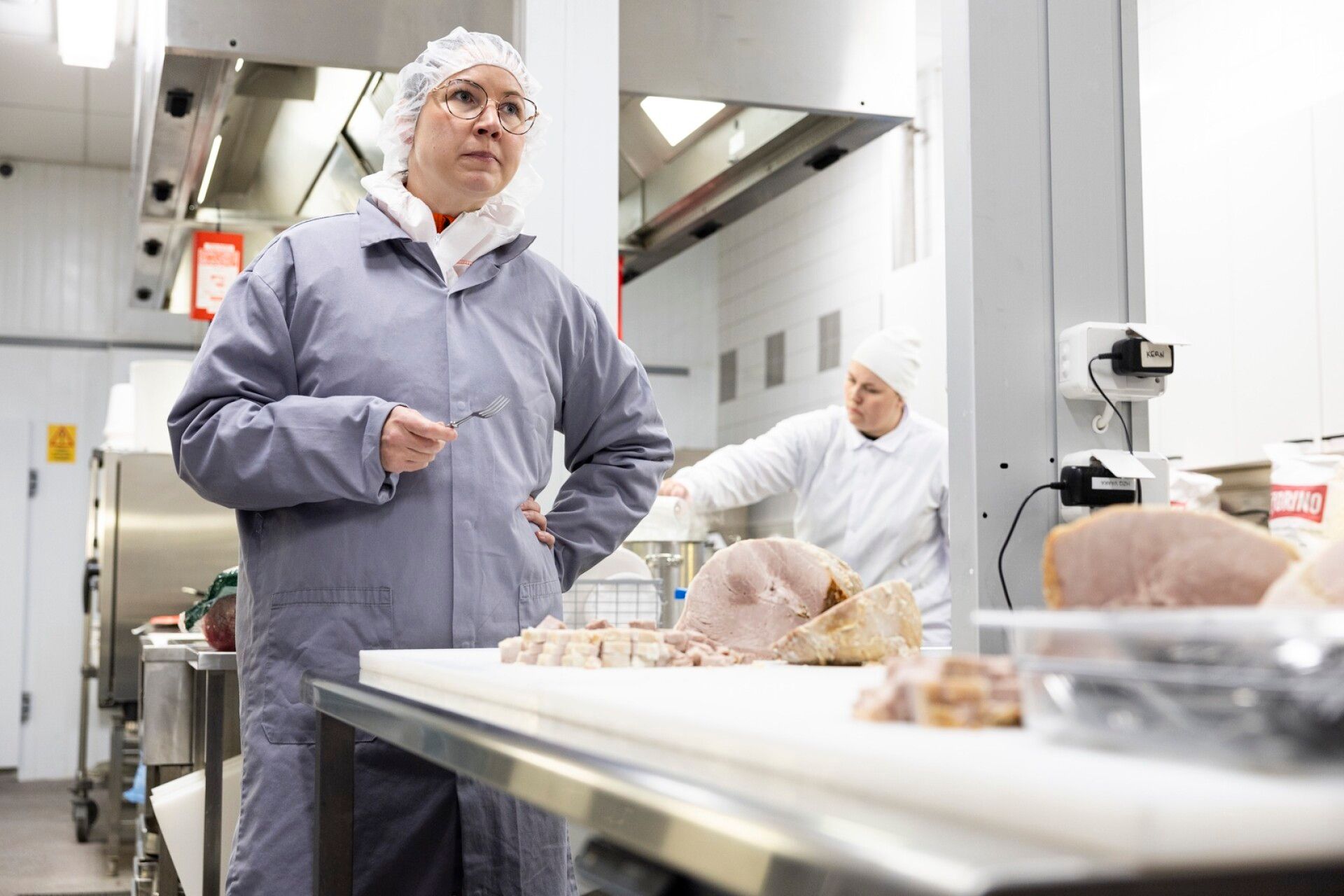 Atrian lihaliiketoiminnan tuoteryhmäpäällikkö Eeva Juva pääsee silloin tällöin maistelemaan tuotteita. Taustalla näkyy Atrian koekeittiö.