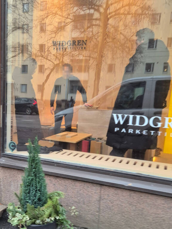 Sanna ja Joni katselivat, kun työntekijä esitteli eri parkettimalleja.