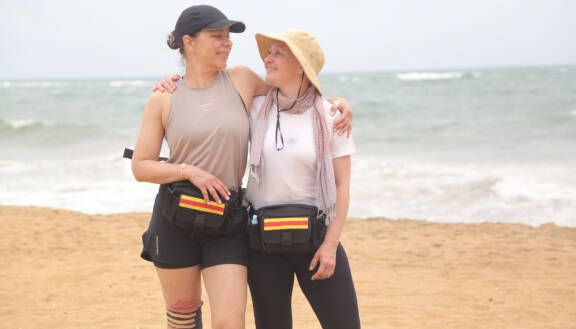 Armi Toivanen ja Sari Majamaa rannalla kädet toistensa ympärillä.