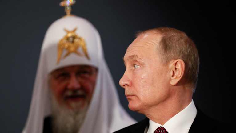 Putin katsoo sivulle ja patriarkka Kirill sumeana takana