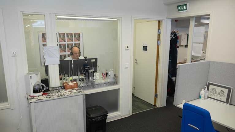 Mies puhuu kopissa kuulokkeet päässä videopuhelua.