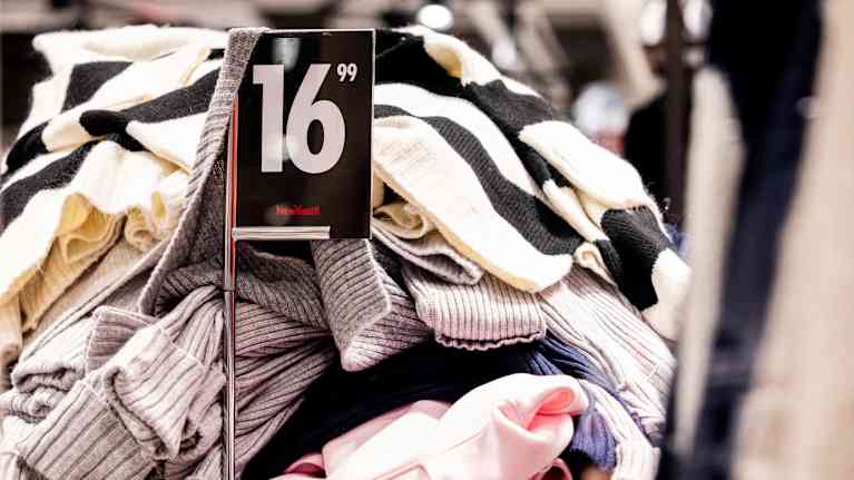 Iso kasa vaatteita sekaisin vaateliikkeen pöydällä hintaan 16.99.