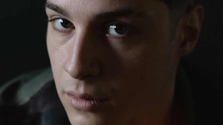 Aris potrettikuvassa, kuvattu hitusen ylhäältä käsin, katse sivulle yläviistoon kohti kameraa.