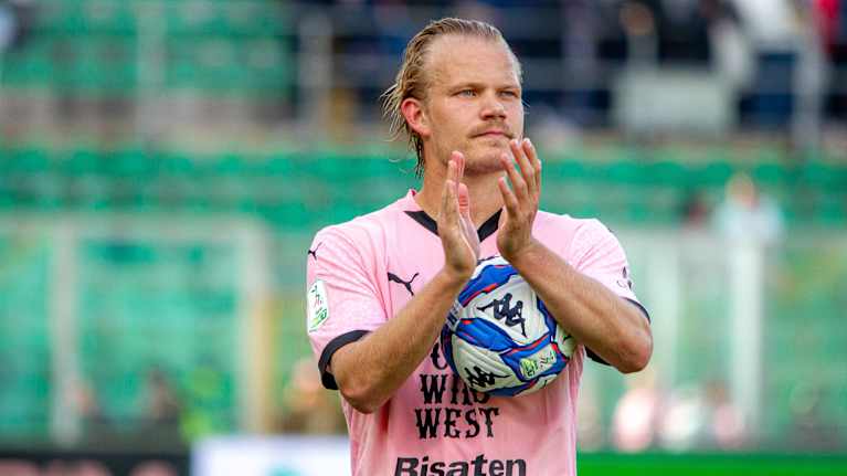 Joel Pohjanpalo taputtaa käsiään pallo sylissään.