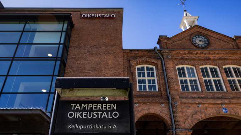 Tampereen oikeustalon julkisivu ja kyltti.