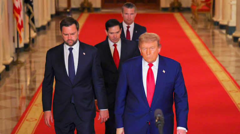 Neljä henkilöä kävelee Valkoisessa talossa.