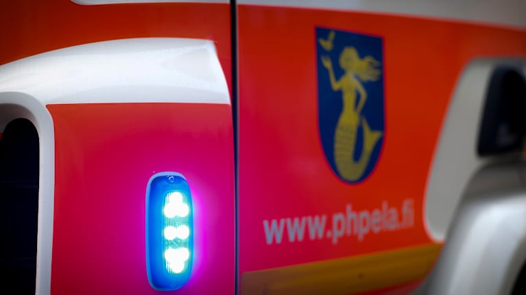 Paloauton sininen vilkku ja auton ovi.