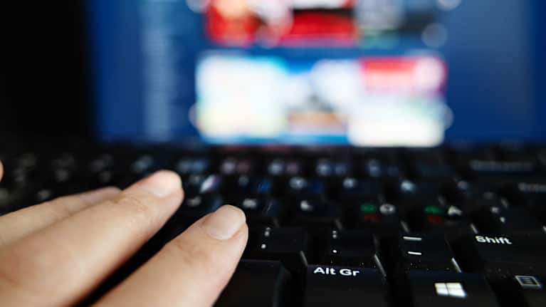 Kuvattu Stream-pelifirman sivuja tietokoneen näytöltä. Etualalla sormet ja näppäimistö.