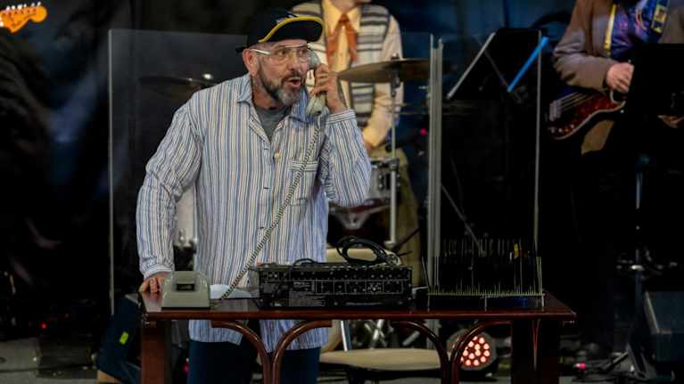 Esko Eerikäinen puhuu puhelimessa Rauhalahden kesäteatterin esityksessä Kuopiossa.