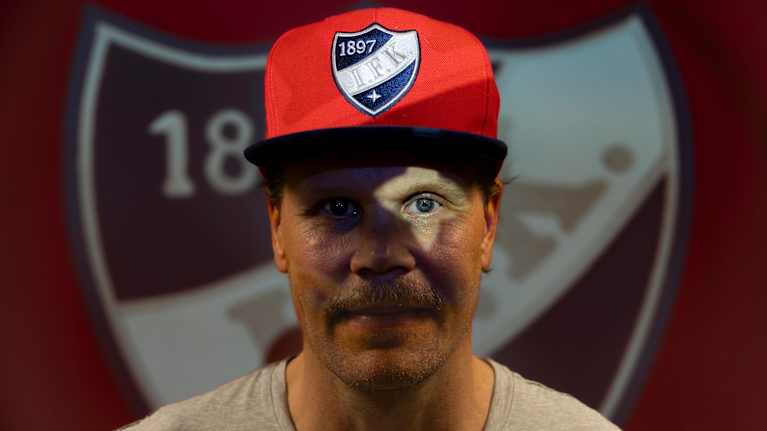 HIFK:n päävalmentaja Olli Jokinen poseeraa HIFK-logon edessä, valo muodostaa tähtikuvion hänen silmäänsä.