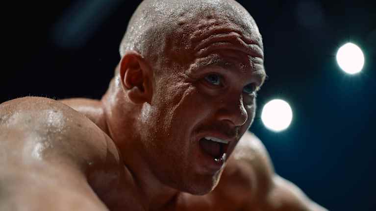 Urheilijamies seisoo hikisenä rankan urheilusuorituksen keskellä.