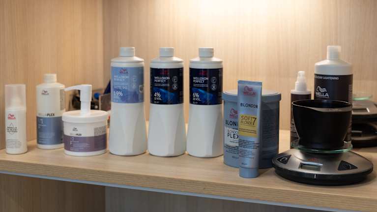 Vaaka, sekoitusastia ja hiustenvaalennustuotteita.