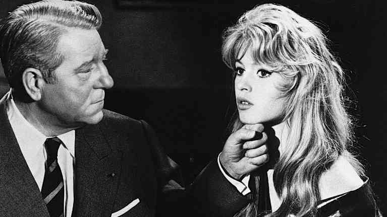 Jean Gabin pitää kättään Brigitte Bardot'n leuan alla. Gabinilla on tumma puku ja kravatti. Bardot'lla on yllään avonainen kylpytakki.