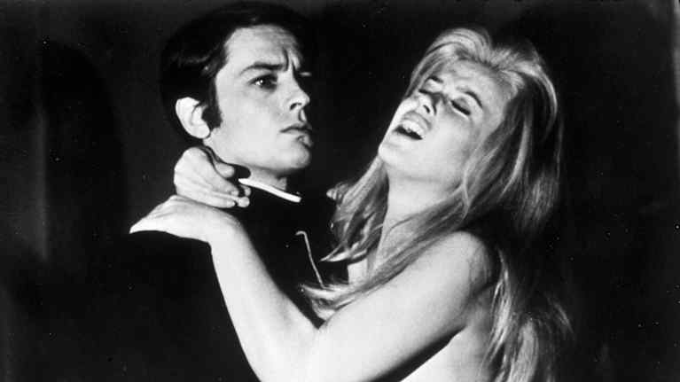 Tummiin pukeutunut Alain Delion pitää Brigitte Bardot'ta sylissään mustavalkoisessa kuvassa. Delonin ilme on vakava, Bardot näyttää tuskaiselta.