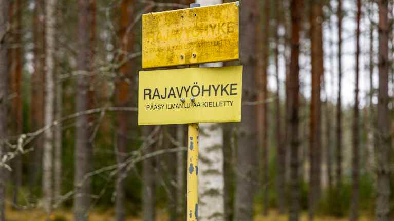 Rajavyöhyke, pääsy ilman lupaa kielletty -kyltti metsän reunalla.