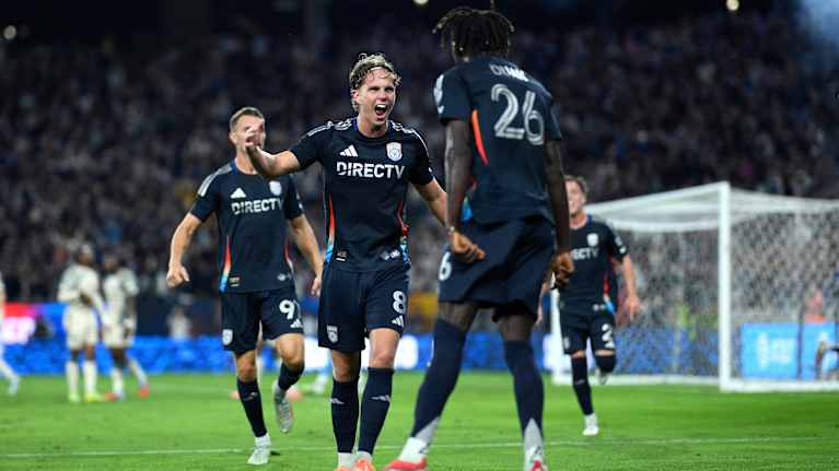 Jalkapallojoukkue juhlii kentällä maalin jälkeen.