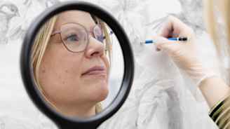 Taiteilija piirtää peilin avulla omakuvaa.