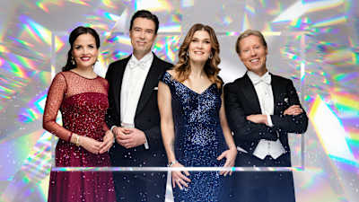 Elegantit iltapukuihin ja frakkeihin pukeutuneet Ylen Linnan juhlien juontajat säihkyvässä miljöössä.