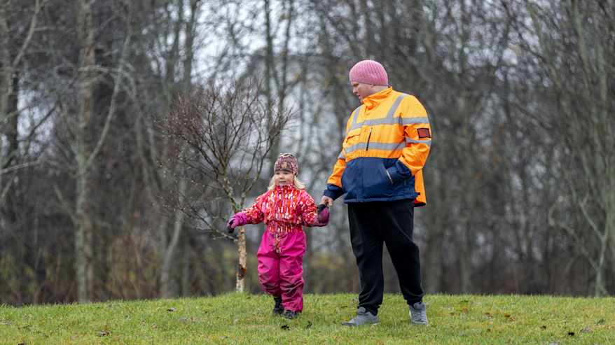 Mies ja lapsi kävelevät leikkipuistossa.