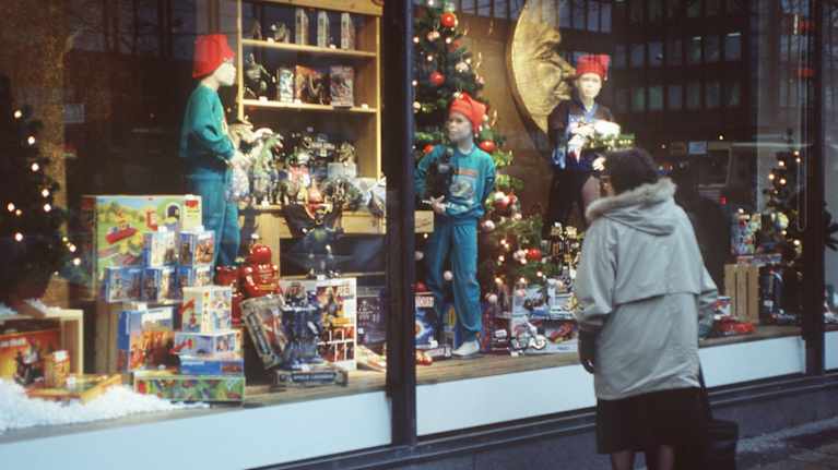 Tavaratalon jouluikkuna, jonka ääressä jouluostoksilla oleva nainen on katsomassa leluja vuonna 1993.
