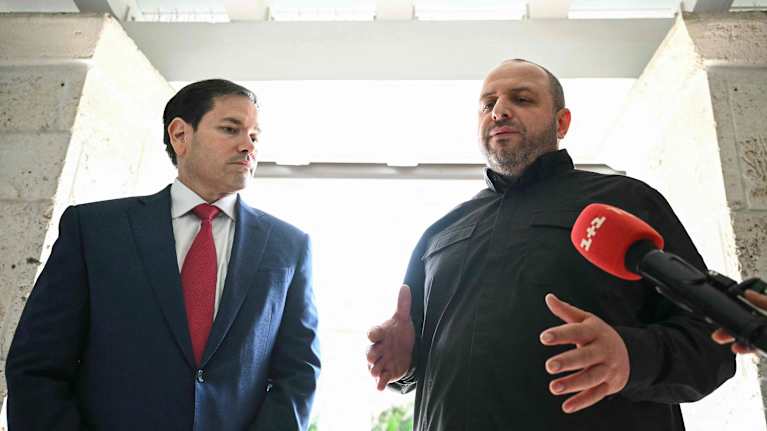 Kaksi miestä puhuu mikrofonin edessä.