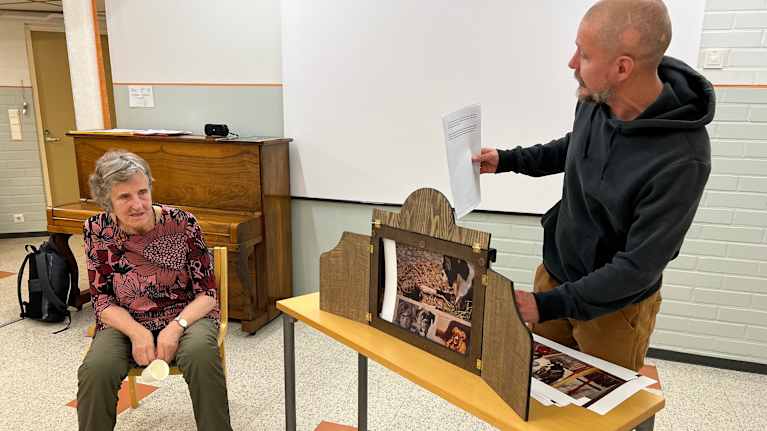 Sirkustaiteilija Pekka Laamanen näyttää kuvia kamishibai-teatterilaitteella hyvinvointikeskus Lehmusvalkamassa.