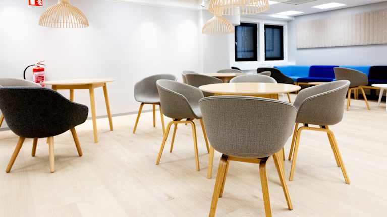 Toimiston keittiön yhteydessä penkkejä ja pöytiä.