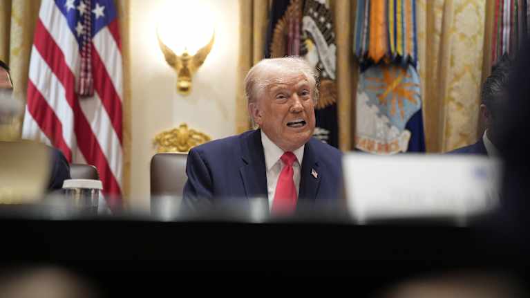 Yhdysvaltain presidentti Donald Trump puhuu pöydän takana.