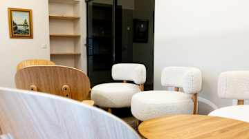 Opiskelija-asunnon yhteistila jossa erilaisia tuoleja ja pöytiä.