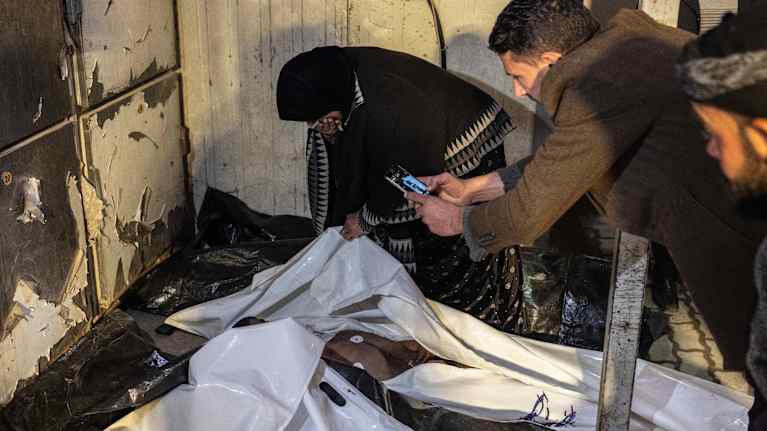 Ihmiset yrittävät tunnistaa vainajaa.