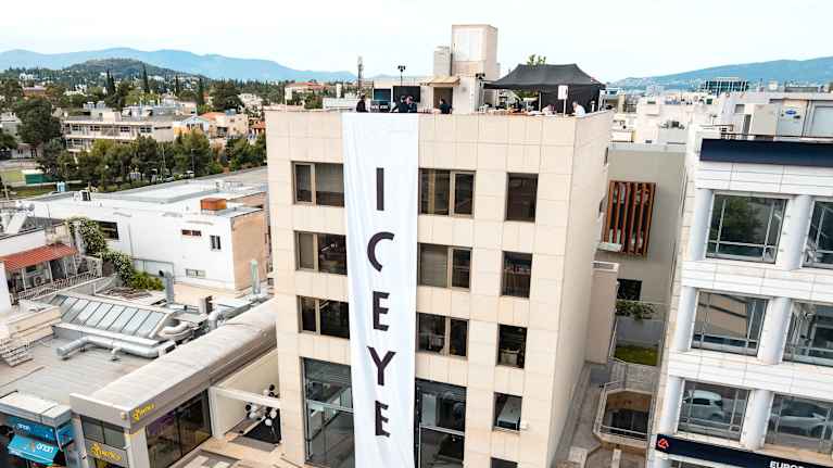 Vaaleanpunainen rakennus kohoaa vuorijonon ympäröimässä kaupunkikuvassa. 