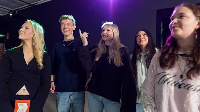 Joukko nuoria taidenäyttelyssä.