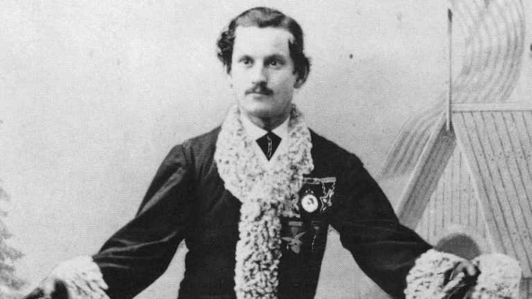 Mustavalkoisessa kuvassa amerikkalainen Jackson Haines luistelee 1800-luvun lopun luistimilla tyylikkäästi pukeutuneena.