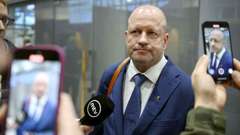 Timo Vornanen oikeustalon aulassa, missä kännykkäkuvaajat ottavat hänestä kuvia.