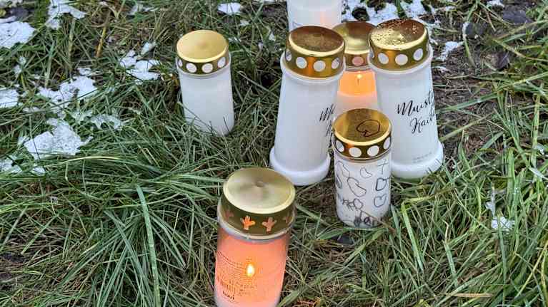Muistokynttilöitä pihamaalla.