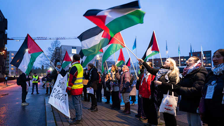 Mielenosoitus, jossa osallistujat heiluttavat palestiinalaisia lippuja.