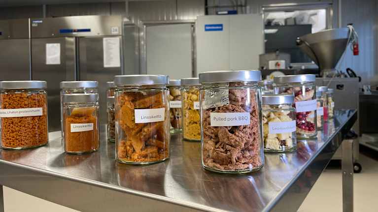Pöydällä pakastekuivattuja tuotteita pakattuna lasipurkkeihin. 