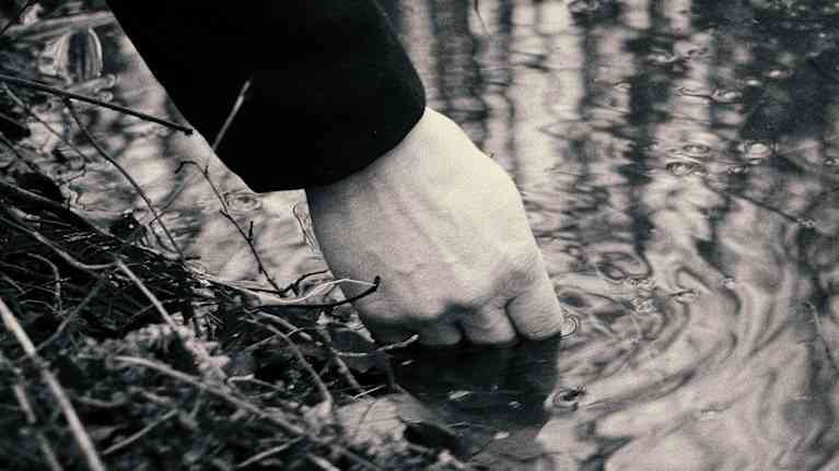 Kirjailija Aki Ollikaisen käsi Tattarisuon lähteessä. 