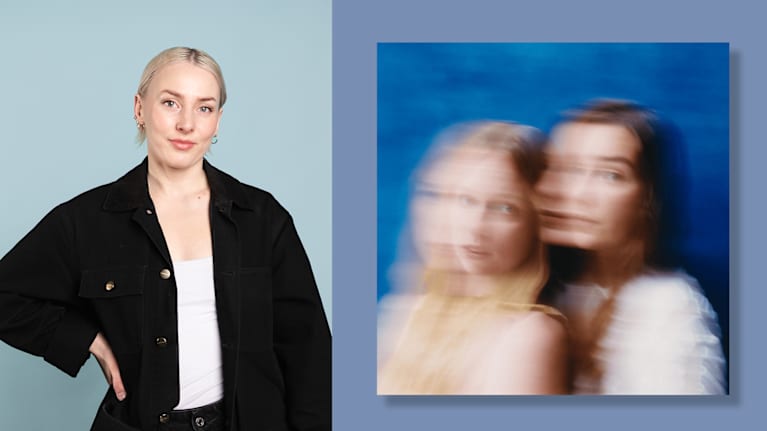 Mustaan takkiin pukeutunut nainen seisoo käsi lanteellaan. Oikealla levynkansi, jonka epätarkassa kuvassa on kaksi naista katsovat kameraan.