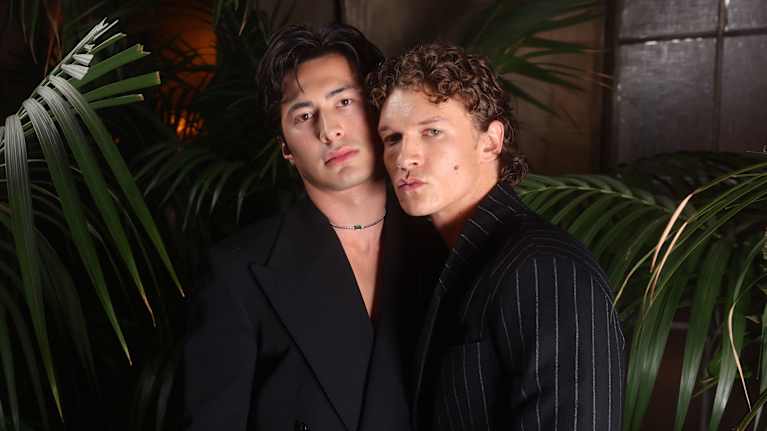 Kaksi komeaa mustapukuista miesnäyttelijää poseeraavat katsoen suoraan kameraan, suutaan suipistaen.