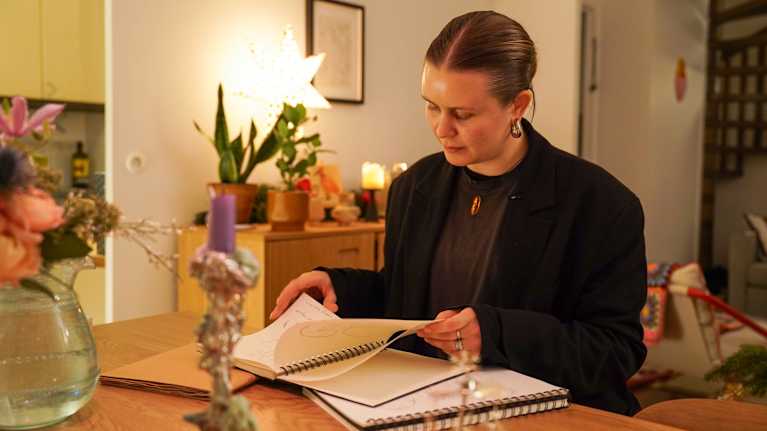 Greetta Ripatti katselee piirroksiaan kotonaan.