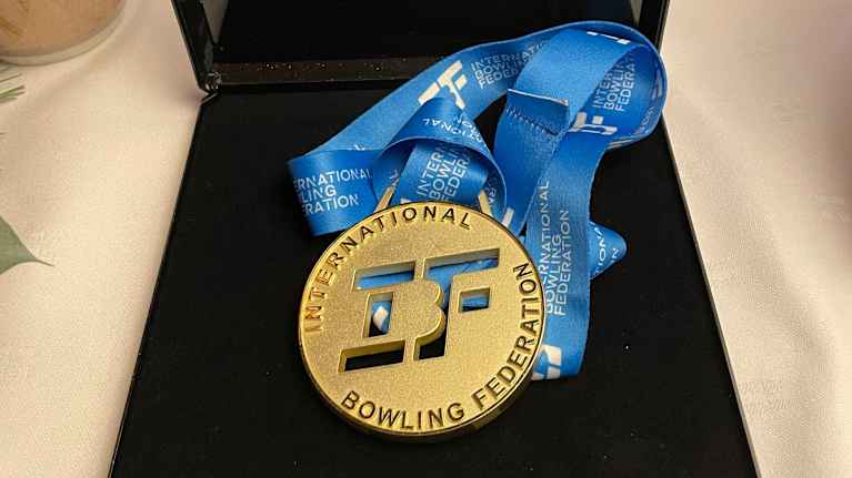 Keilauksen MM-kultamitali mustalla alustalla.